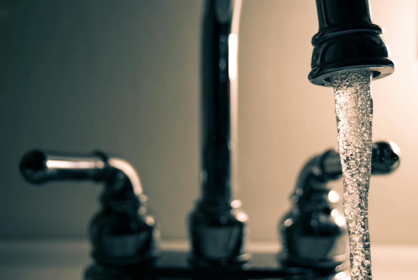 Laufender Wasserhahn an einem Waschbecken aus Chrom